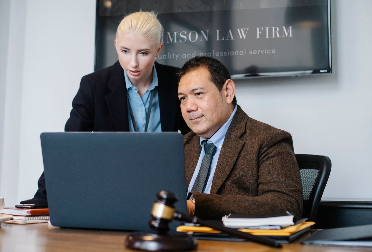 Mastering the First Impression: Your intriguing post title goes here Smart mature ethnic judge in suit working on laptop and discussing details of new case with young female assistant in law firm
